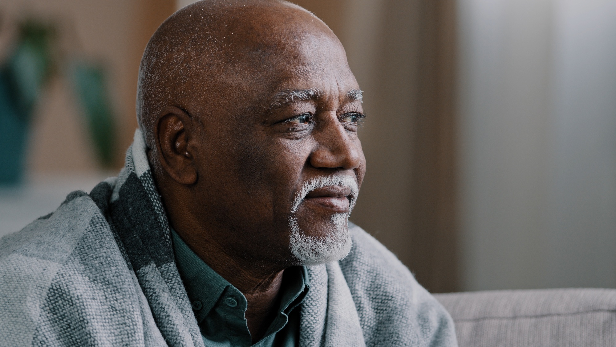 Unhealthy mature elderly grandpa looking away in window pensive sick African American man suffering